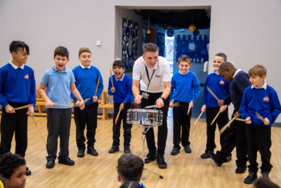 A teacher and multiple students practicing drumming