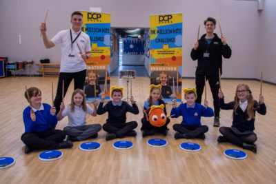 DCP Drums teachers with students from Haddon Primary & Nursery School holding drum sticks